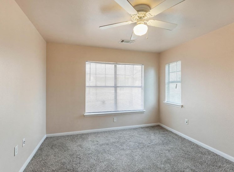 Bedroom with wall to wall carpet, ceiling fan, and windows